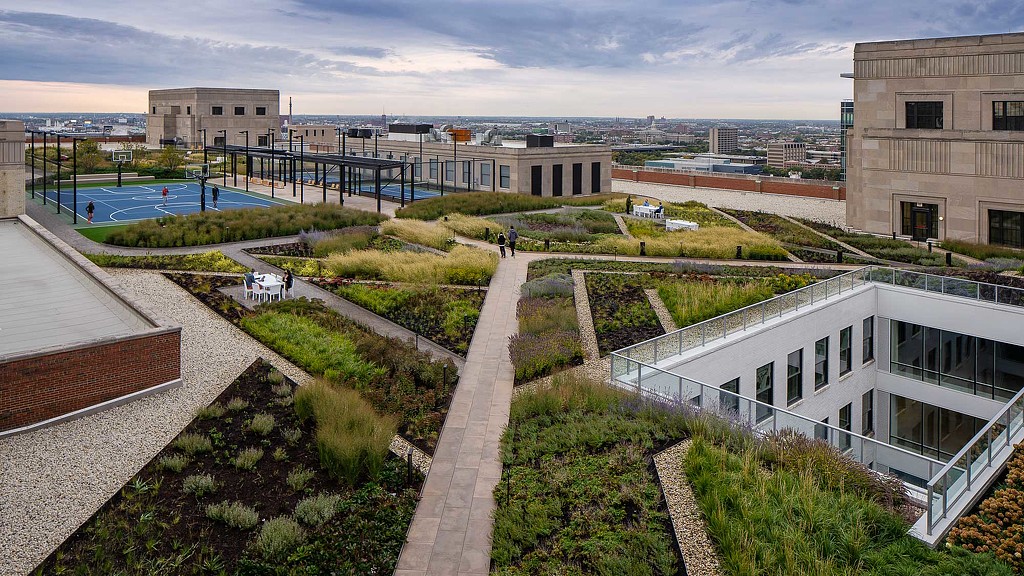 A courtyard with a building and a pool in the background.